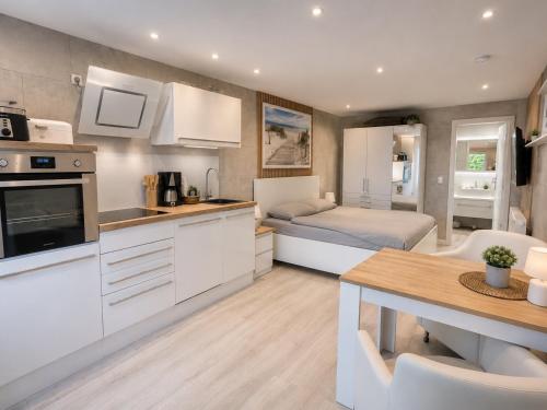 a kitchen and living room with a bed and a table at Bungalow Seeblick Am Achterwasser in Ueckeritz