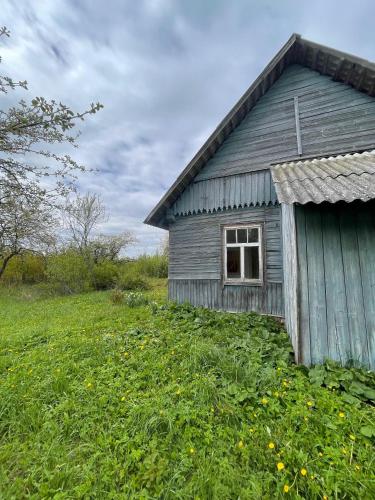 an old wooden house in a field of grass at The White MEADOW in Titova