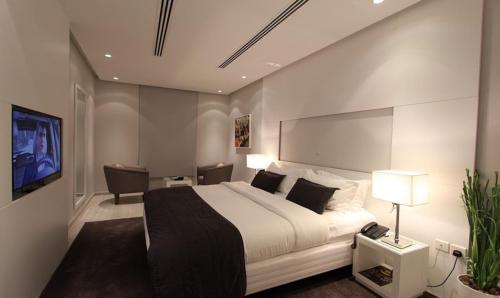 a bedroom with a large bed and a tv at Rafa in Riyadh