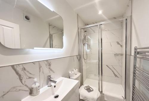 a white bathroom with a sink and a shower at Large central studio Sleep 3 in Brighton & Hove