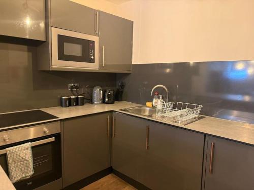 a kitchen with a sink and a microwave at Large central studio Sleep 3 in Brighton & Hove