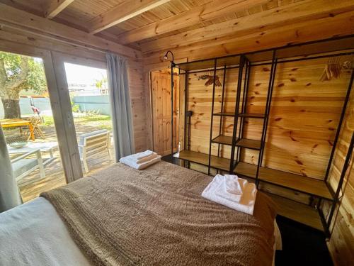 a bedroom with a bed in a wooden cabin at Encanto de Azeitão in Aldeia de Irmãos