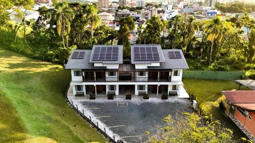 a house with solar panels on the roof at Ipê Eco Village, Apartamentos perto do Beto Carrero in Penha