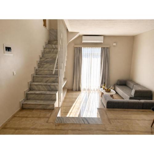 a living room with a staircase and a couch at Loriet Hotel in Mytilene
