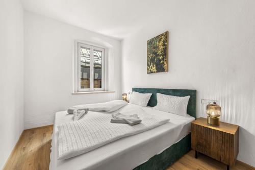 a white bedroom with a large bed and a window at easy-flat Hauptplatz - City Center Apartments with a Kitchen in Villach