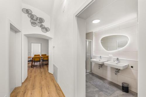 a white bathroom with two sinks and a dining room at easy-flat Hauptplatz - City Center Apartments with a Kitchen in Villach