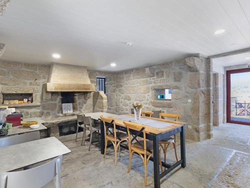 a kitchen and dining room with a table and chairs at Quinta do Avô - Casa de Campo in Terras de Bouro
