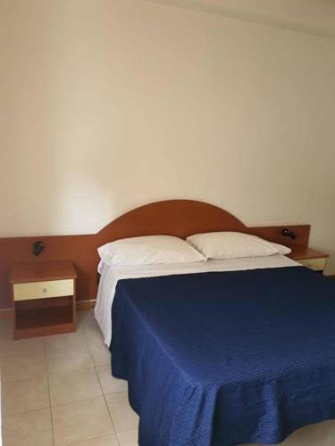 a bedroom with a bed with a blue blanket on it at Appartamenti Bellavista Club Tropea in Tropea