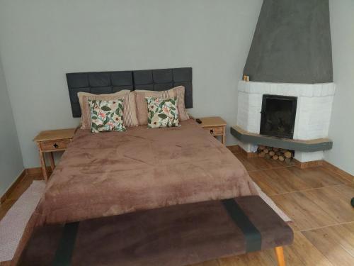 a bedroom with a large bed with a fireplace at Chalé Jaguary com hidro,Monte Verde MG in Companhia