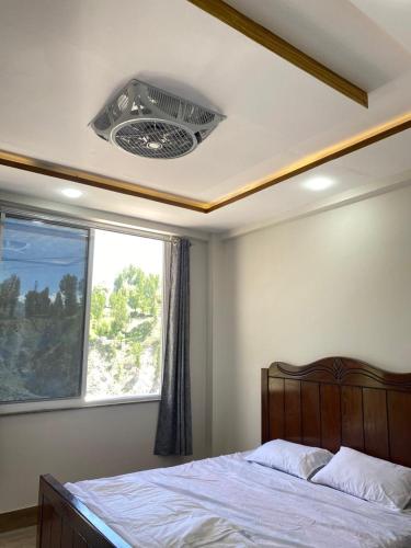a bedroom with a bed with a window and a fan at Hill View Hotel in Astor