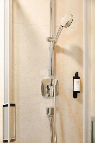 a shower with a shower head in a bathroom at TWILL Apartments in Brno