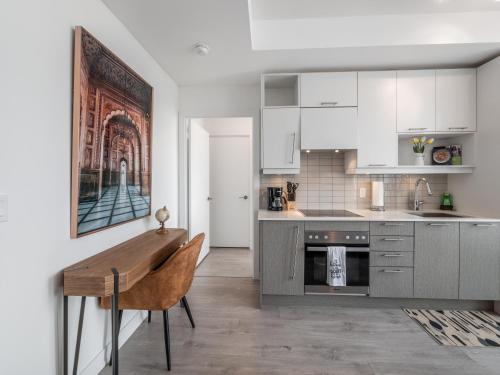 a kitchen with white cabinets and a wooden table at Atlantis Suites The Entertainment District - Toronto in Toronto