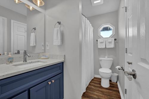 a bathroom with a sink and a toilet and a mirror at All Marshed Up-Stunning Water View 1 block to beach in Surf City