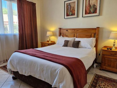 a bedroom with a large bed and two night stands at Villa Sardinia Guest House in Midrand