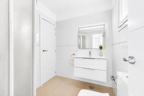 a white bathroom with a sink and a mirror at DUPLEX C9 con PISCINA PRIVADA in Callao Salvaje