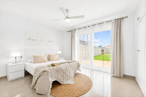 a white bedroom with a bed and a large window at DUPLEX C9 con PISCINA PRIVADA in Callao Salvaje