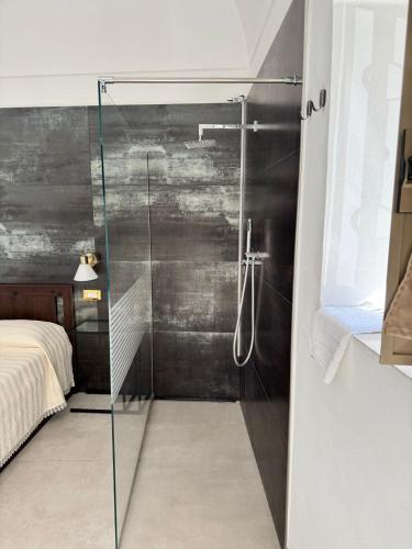 a glass shower in a bedroom with a bed at Stanza dei Desideri in Peschici