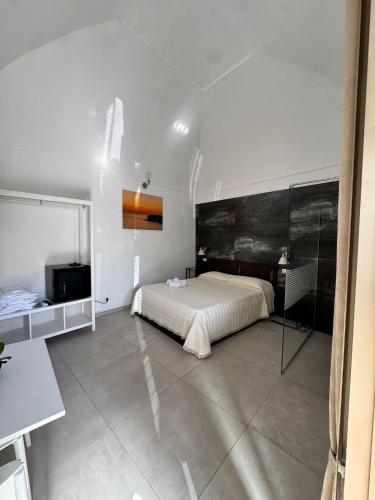 a white bedroom with a bed and a mirror at Stanza dei Desideri in Peschici