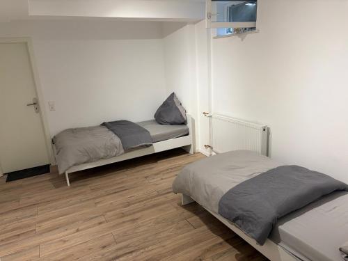a bedroom with two beds and a wooden floor at Ferienwohnung Elli in Haiterbach