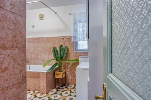 a bathroom with a tub and a potted plant at Riva Luxury Seafront in Rabac