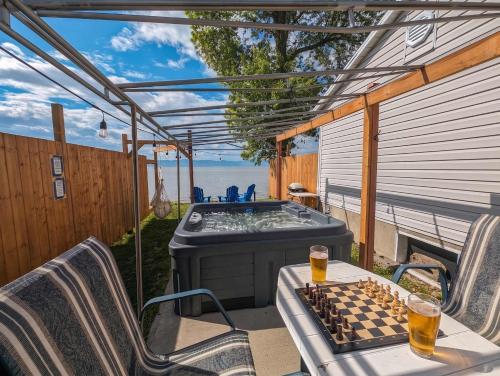 a hot tub on a patio with a chess board on a table at Chalet #10 - Spa & Fireplace in Cap-Saint-Ignace