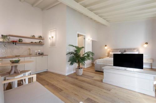 a white bedroom with a bed and a television at Vila Santa Luzia 6 in Fátima