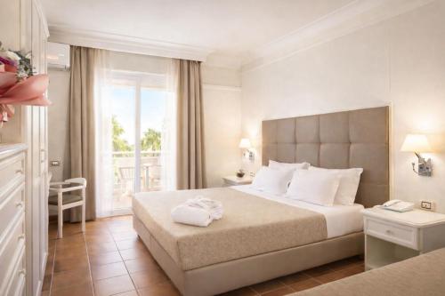 a hotel room with a large bed and a window at Baia Di Ulisse Wellness & Spa in San Leone