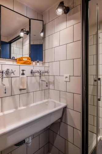 a bathroom with a sink and a mirror at Eklo Hotels Lille in Lille