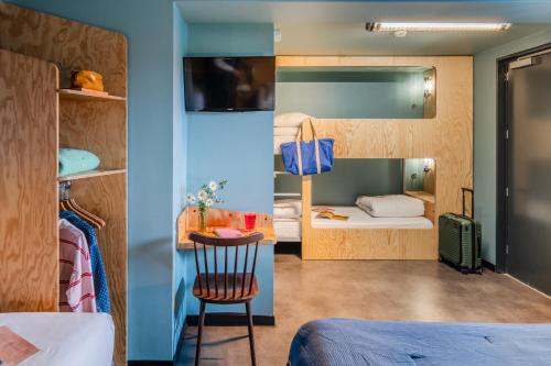 a room with two beds and a table and a chair at Eklo Hotels Lille in Lille