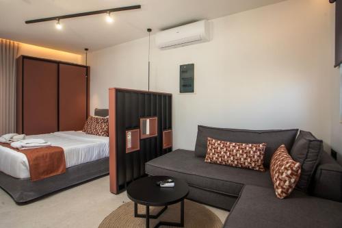 a hotel room with a bed and a couch at Central Point - Kallithies Village Square by GM in Kalithies