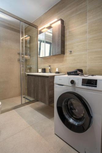 a washing machine in a bathroom with a sink at Central Point - Kallithies Village Square by GM in Kalithies