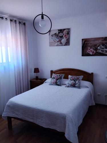 a bedroom with a large bed with two pillows at Lélé in Vila Praia de Âncora
