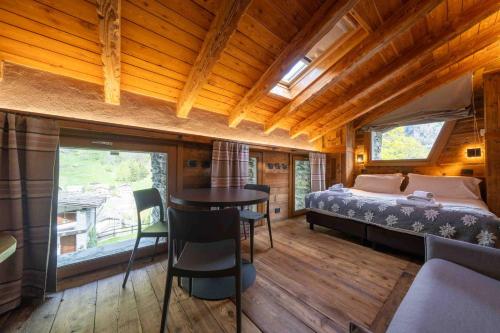 a bedroom with a bed and a table in a room at Chalet Les Airelles in Valtournenche