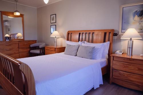 a bedroom with a large white bed and a mirror at Hotel Renar in Fraiburgo