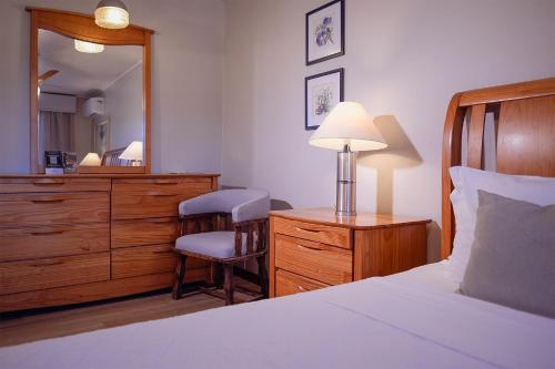 a bedroom with a bed and a dresser and a mirror at Hotel Renar in Fraiburgo
