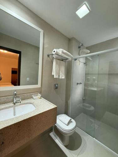 a bathroom with a toilet and a sink and a shower at Hotel Kennedy in São José