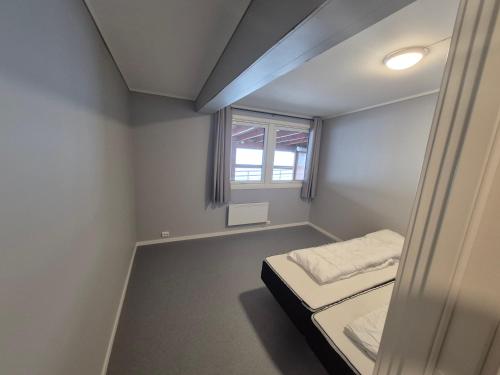 a small room with a bed and a window at Egenes Camping in Flekkefjord