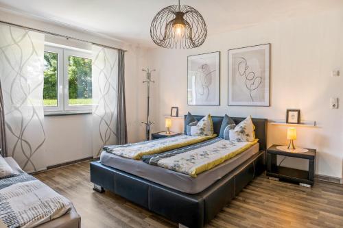 a bedroom with two beds and a chandelier at Fewo Franken in Goldkronach