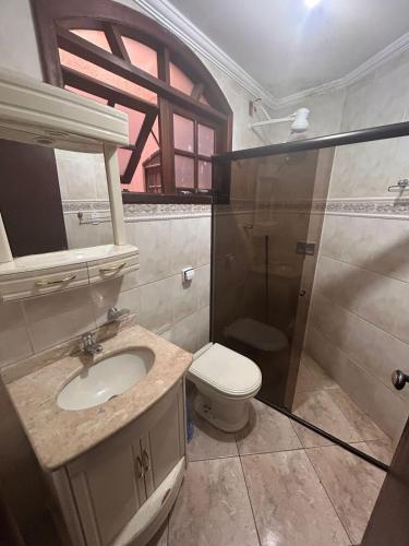 a bathroom with a sink and a toilet and a shower at Hotel Akuto's in Aparecida