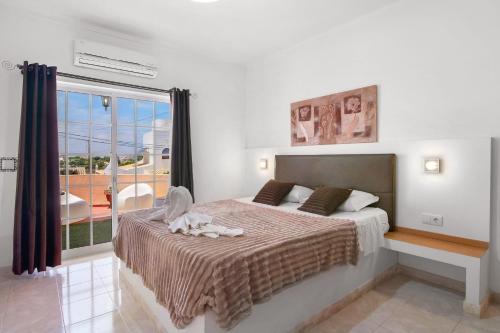 a bedroom with a bed and a large window at South Star Guesthouse in Quelfes