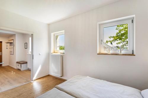 a white room with a bed and a window at Ferienhaus Lilla Huset in Neheim-Hüsten