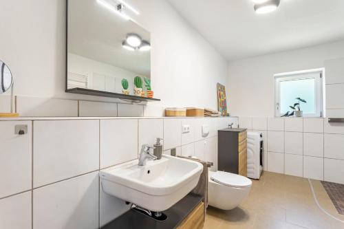 a white bathroom with a sink and a toilet at Ferienhaus Lilla Huset in Neheim-Hüsten