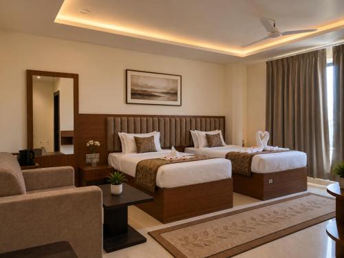 a hotel room with two beds and a couch at Hotel Royal Ashoka in Rājgīr