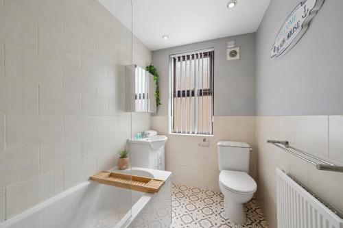 a bathroom with a toilet and a tub and a sink at Rockland Retreat - Near Crosby Beach & Liverpool in Waterloo