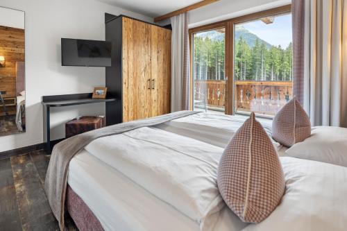 a bedroom with a large bed and a large window at Nationalpark Chalet Blessachkopf in Neukirchen am Großvenediger