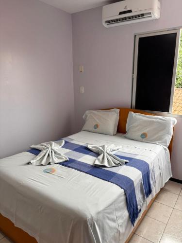 a bedroom with a bed with a blue and white blanket at Pousada Planalto in Juazeiro do Norte