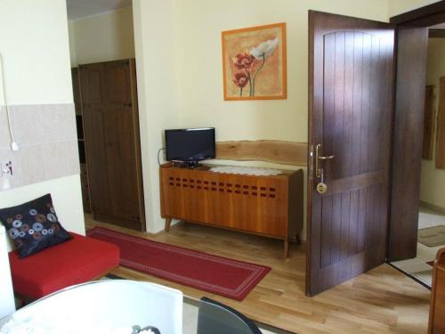 a living room with a door and a tv at Hotel Diána in Pécs