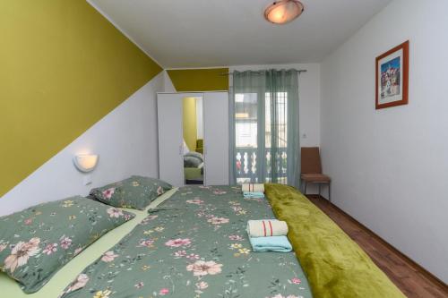 a bedroom with a large bed with a green blanket at Apartments Albina in Lopar