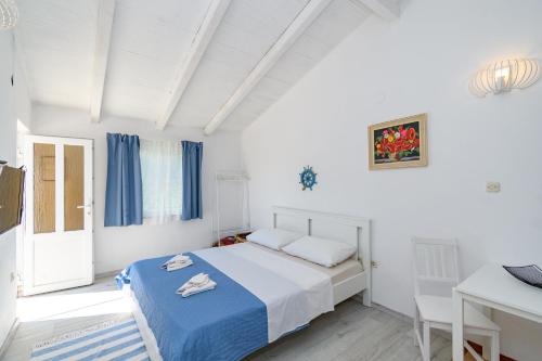 a bedroom with a bed and a table and a desk at Apartments Sime in Lopar