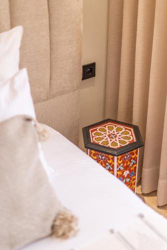 a bedroom with a bed and a night stand at Riad Villa Alain in Nouaceur